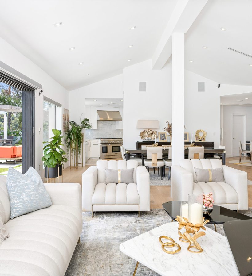 Some white couches and expansive windows offering scenic views in a stylish living room